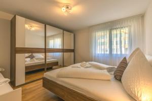 a bedroom with a large bed and a mirror at Harder Apartment - Aare Jungfrau AG in Wilderswil +15 photos