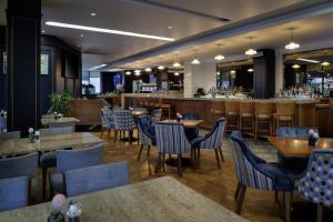 a restaurant with tables and chairs and a bar at Hilton Dublin Kilmainham in Dublin +80 photos