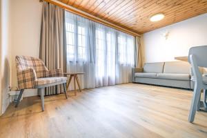 a living room with a couch and a chair at First Apartment - Aare Jungfrau AG in Grindelwald