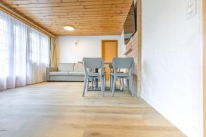 a living room with a table and chairs and a couch at First Apartment - Aare Jungfrau AG in Grindelwald