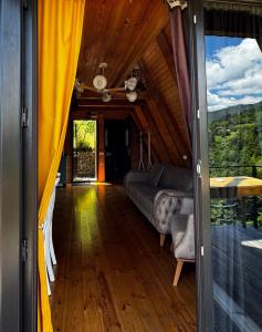 a living room with a couch and a sliding glass door at HillSide Cottage-ჰილსაიდ კოტეჯი in K'eda