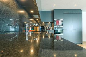 a kitchen with blue cabinets and a black counter top at Schilthorn Apartment - Aare Jungfrau AG in Wilderswil +6 photos