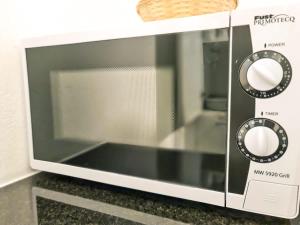 a microwave oven with two knobs on a counter at Nika Apartment - Aare Jungfrau AG in Grindelwald +22 photos