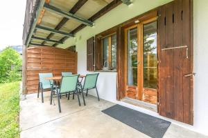a patio with chairs and a table on a house at Lauberhorn Apartment - Aare Jungfrau AG in Grindelwald +8 photos