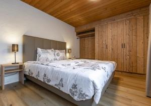a bedroom with a large bed and a wooden ceiling at Apartment Eiger - Aare Jungfrau AG in Grindelwald