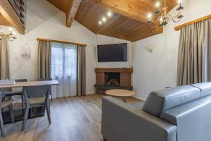 a living room with a couch and a table and a television at Apartment Eiger - Aare Jungfrau AG in Grindelwald