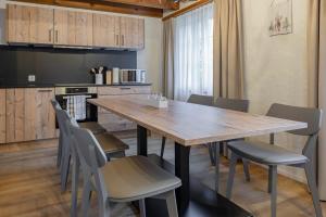 a kitchen with a wooden table and chairs at Apartment Eiger - Aare Jungfrau AG in Grindelwald