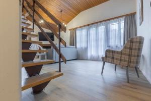 a living room with a staircase and a chair at Apartment Eiger - Aare Jungfrau AG in Grindelwald +11 photos