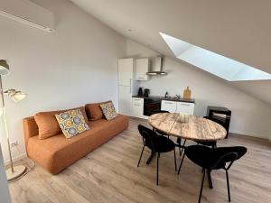 a living room with a couch and a table at Appartement avec jacuzzi et piscine sur les remparts in Langres