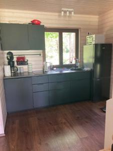 a kitchen with a refrigerator and a sink at Aru talu külalistemaja in Iilaste