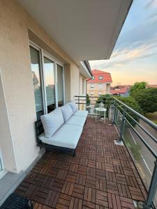 a couch on the balcony of a building at Studio Etoile Elegance in Bartenheim