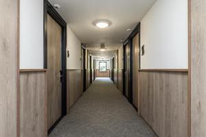 a corridor of a hallway with wooden doors and a hallway at Alpine Hotel by SnowWorld in Landgraaf