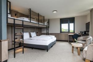a bedroom with a bunk bed and a desk at Alpine Hotel by SnowWorld in Landgraaf