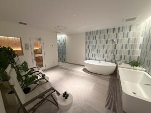 a bathroom with a tub and a sink and a chair at Olympic Inn Azabu in Tokyo +27 photos