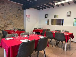 a room with tables and chairs with red tablecloths at Le Moulin de Sournia in Sournia