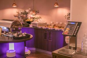 a kitchen with a purple counter with a table with a tablet at Stadtperle Rostock in Rostock