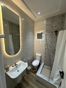 a bathroom with a sink and a toilet and a mirror at Cozy Corner in Sousse