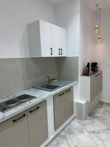 a kitchen with white cabinets and a sink at Cozy Corner in Sousse