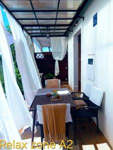 a patio with a table and chairs on a porch at Apartments Relax Zone in Umag