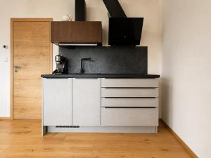 a kitchen with white cabinets and a sink at Apartmán Lidická bouda in Pec pod Sněžkou