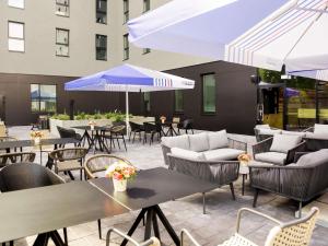 an outdoor patio with tables and chairs and umbrellas at ibis Tallinn Center in Tallinn