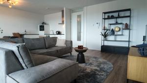a living room with a couch and a table at Residentie De Zeester | 4 Pers. De Zeester in Scherpenisse