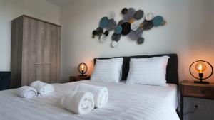 a bedroom with a white bed with towels on it at Residentie De Zeester | 4 Pers. De Zeester in Scherpenisse