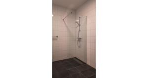 a shower stall in a bathroom with white tiles at Residentie De Zeester | 4 Pers. De Zeester in Scherpenisse +20 photos
