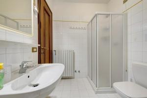 a white bathroom with a sink and a shower at Casa Regina Salò in Salò +30 photos