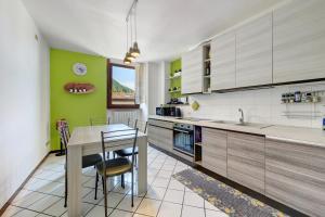 a kitchen with a table and a green wall at Casa Regina Salò in Salò