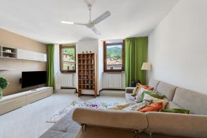 a living room with a couch and a flat screen tv at Casa Regina Salò in Salò