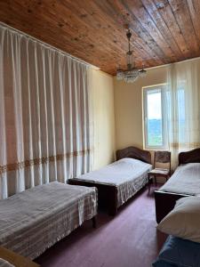 a bedroom with two beds and a wooden ceiling at Tsikhisdziri Hotel in Ts'ikhisdziri