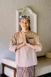 a young boy standing in a room with his hands in front of his face at SHIBUMI - Private Pool & Spa Boutique Villa in Ubud +46 photos