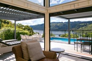 un porche cubierto con vistas al agua en The Point Villas, en Taupo