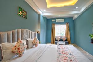 a bedroom with a large bed with blue walls at De Alcazar Calangute in Calangute