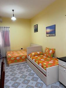 a bedroom with two beds and a desk at Velipoja Hospitality in Velipojë