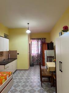 a kitchen with a table and a kitchen with yellow walls at Velipoja Hospitality in Velipojë +2 photos
