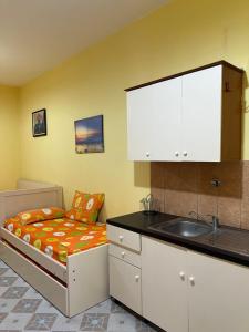 a small kitchen with a bed and a sink at Velipoja Hospitality in Velipojë