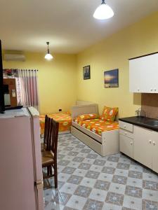 a kitchen and a bedroom with a bed and a refrigerator at Velipoja Hospitality in Velipojë