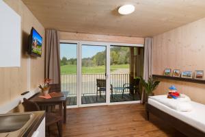 a living room with a bed and a balcony at RAMSI euer Familienhotel in Hermagor