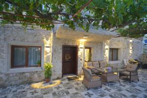 a patio with chairs and a table in front of a house at Diamond Village Ortahisar in Ürgüp