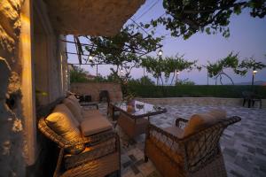 a patio with couches and a table and chairs at Diamond Village Ortahisar in Ürgüp