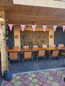 a restaurant with a long wooden table and chairs at La Camuflaj 2 Mai in 2 Mai +6 photos