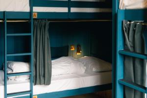 a bed in a room with two bunk beds at Base Camp Hathersage, YHA Partner in Hathersage