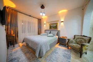 a bedroom with a bed and a chair at Diamond Village Ortahisar in Ürgüp
