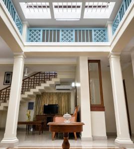 a living room with a staircase and a table at Sky Villa in Trichūr