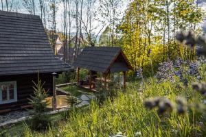 a cabin with a gazebo in a garden at Zbojnícke Chalúpky in Čavoj
