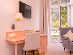 a home office with a desk and a tv on the wall at BE BIO Hotel be active - Nähe historischer Hafen in Tönning