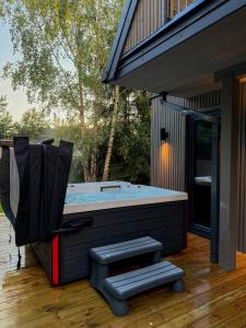 a jacuzzi tub on a deck next to a house at Fale i Igły in Sasino