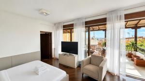 a white living room with a television and a chair at Makadam Hotel in Prizren